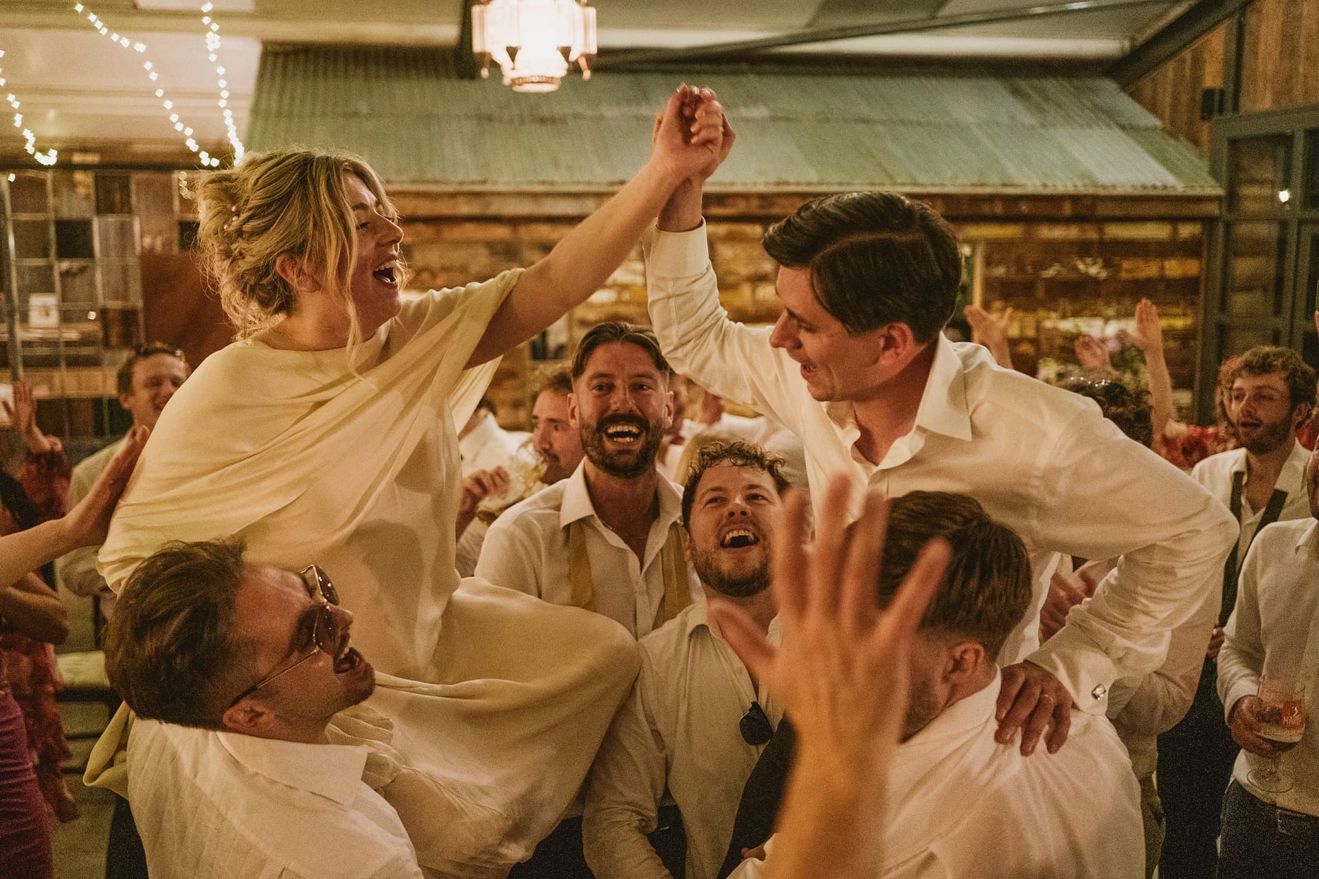 Bride and groom celebrate on the dancefloor, captured perfectly in the moment by Documentary wedding photographers Dominique &