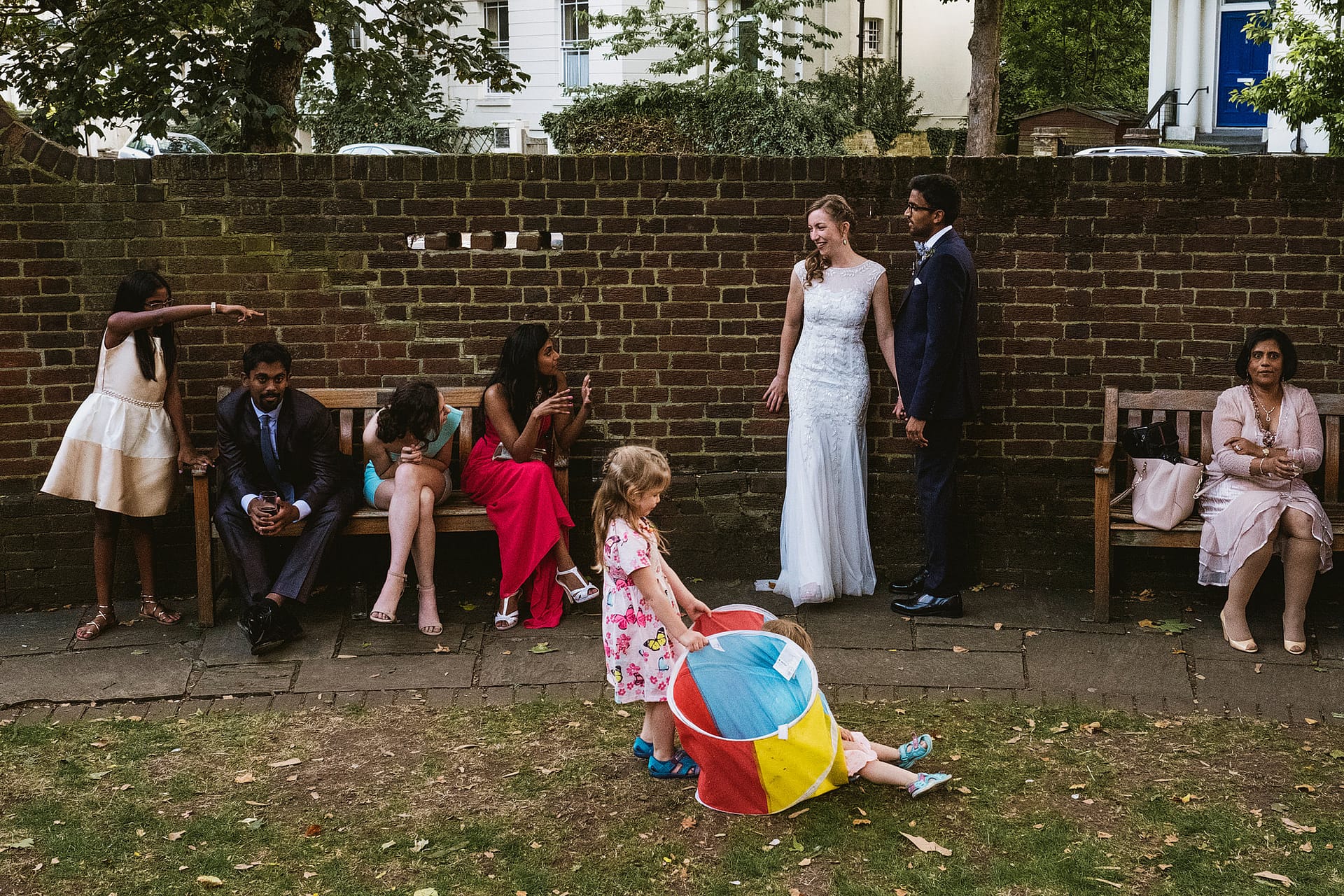 Cecil Sharp House London - a wedding photographer's guide, featured image - wedding guests and bride and groom inside the gardens at Cecil House