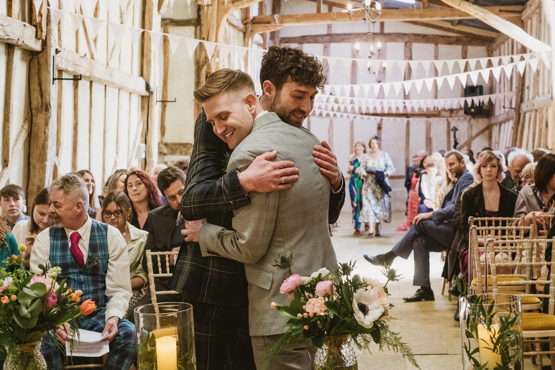 groom and best man hug before ceremony at Alpheton Barns
