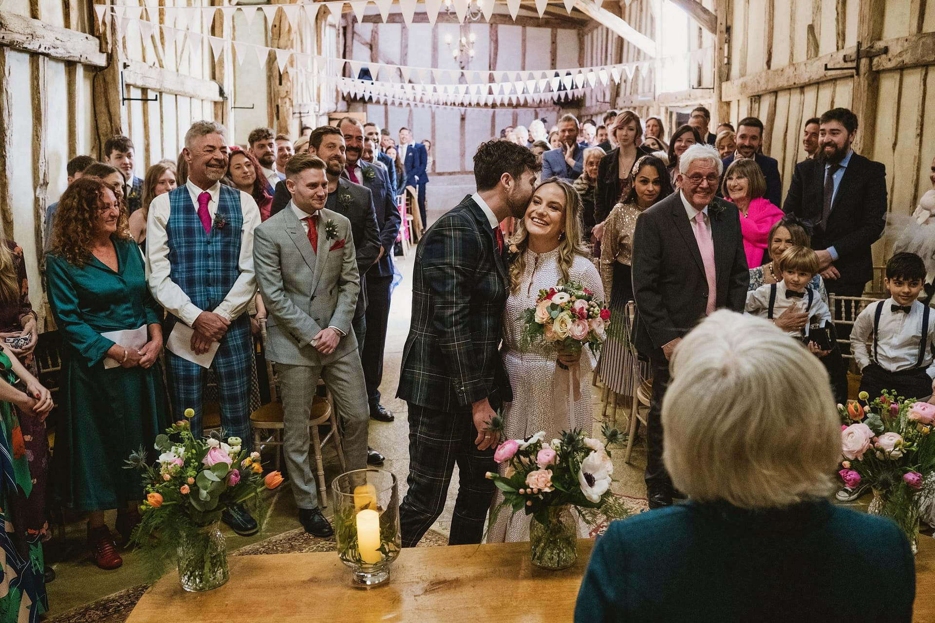 groom kissing bride on cheek at Alpheton Barns ceremony in suffolk