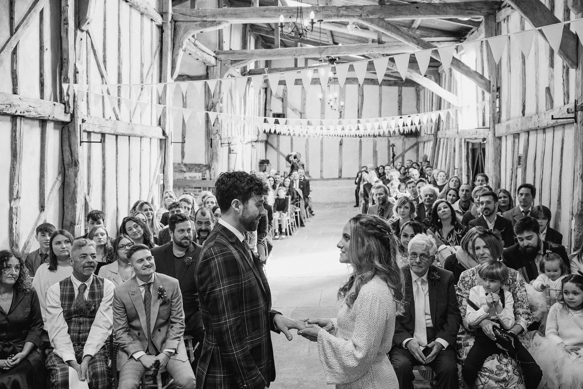 bride and groom exchange rings at Alpheton Barns