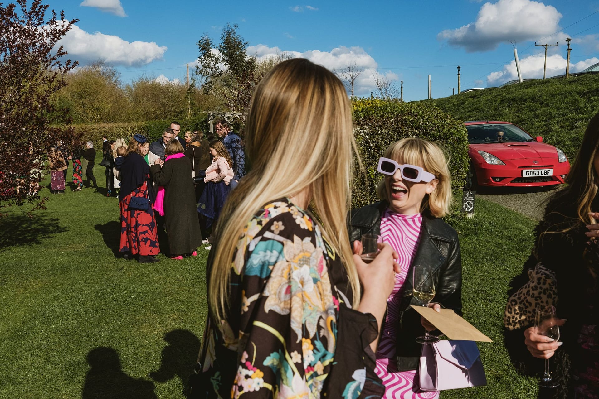 Alpheton Barns wedding photography, wedding guests with red car in background
