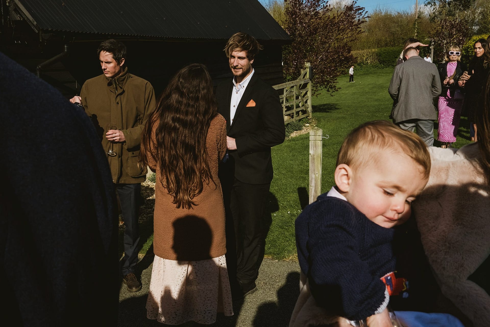 wedding guests bathed in light at Alpheton Barns wedding reception