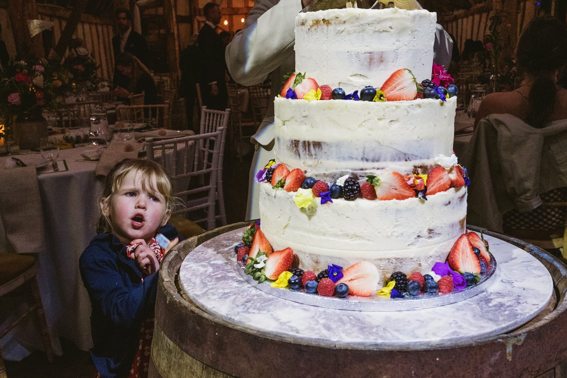 little child looking at wedding cake at Alpheton Barns
