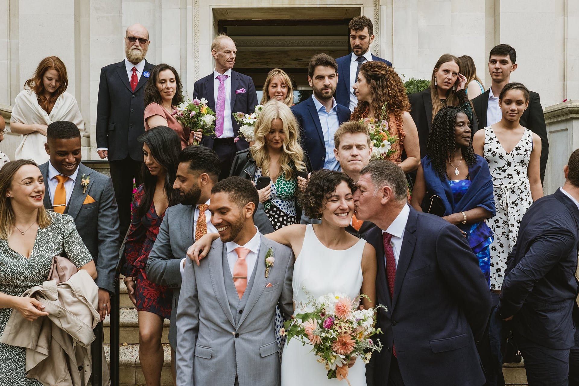 bride and groom surrounded by wedding guests at islington town hall