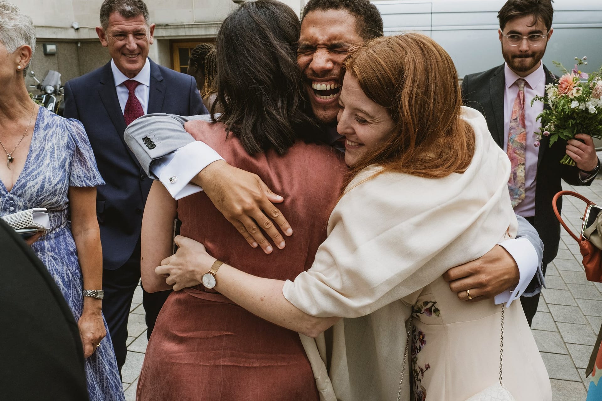 groom hugging wedding guests at islington town hall