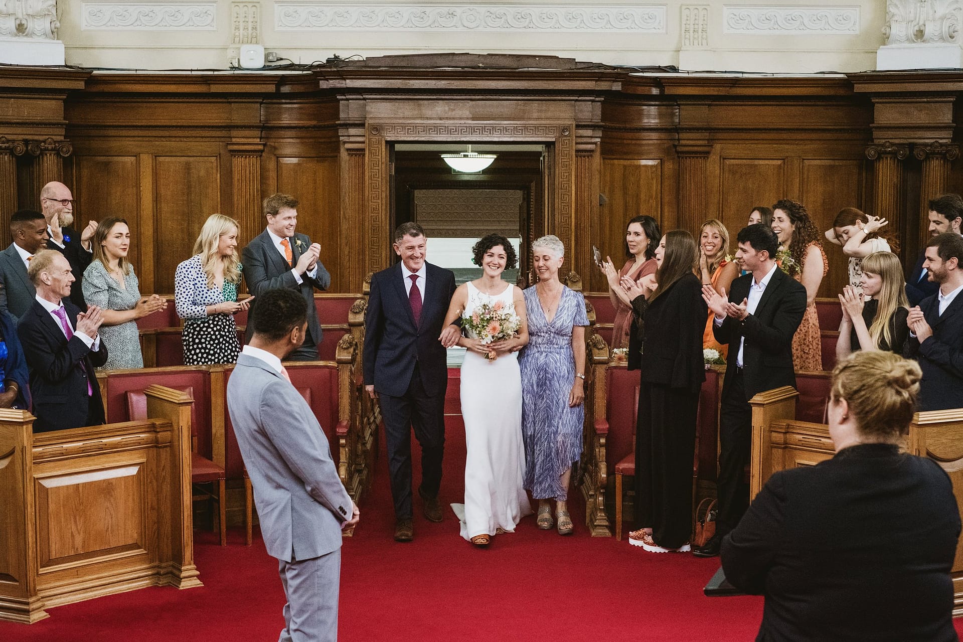 bride coming into ceremony with her parents at islington town hall