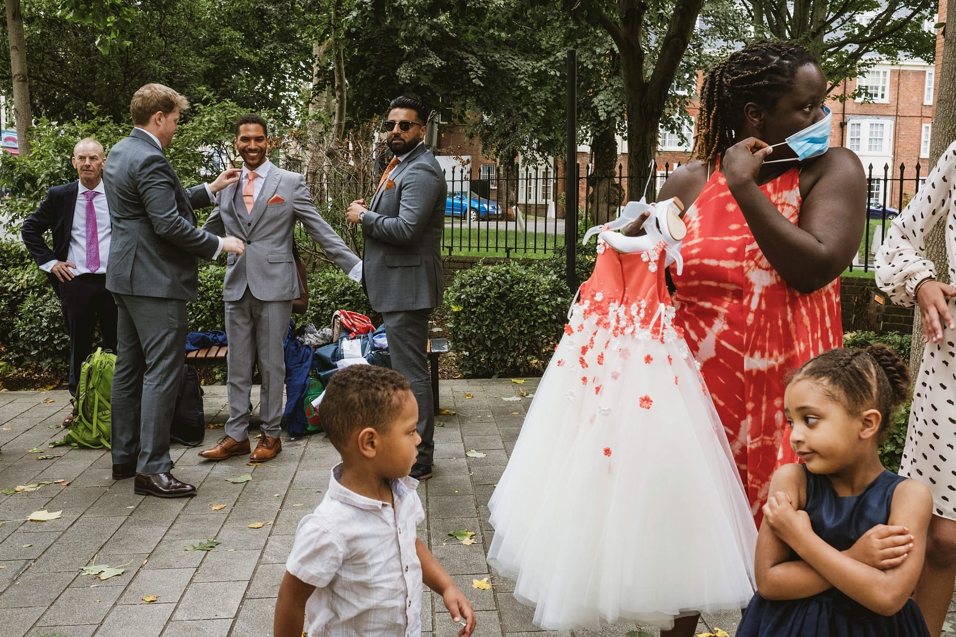 groom getting ready outside the london venue Islington Town Hall with flower girl waiting to put her dress on