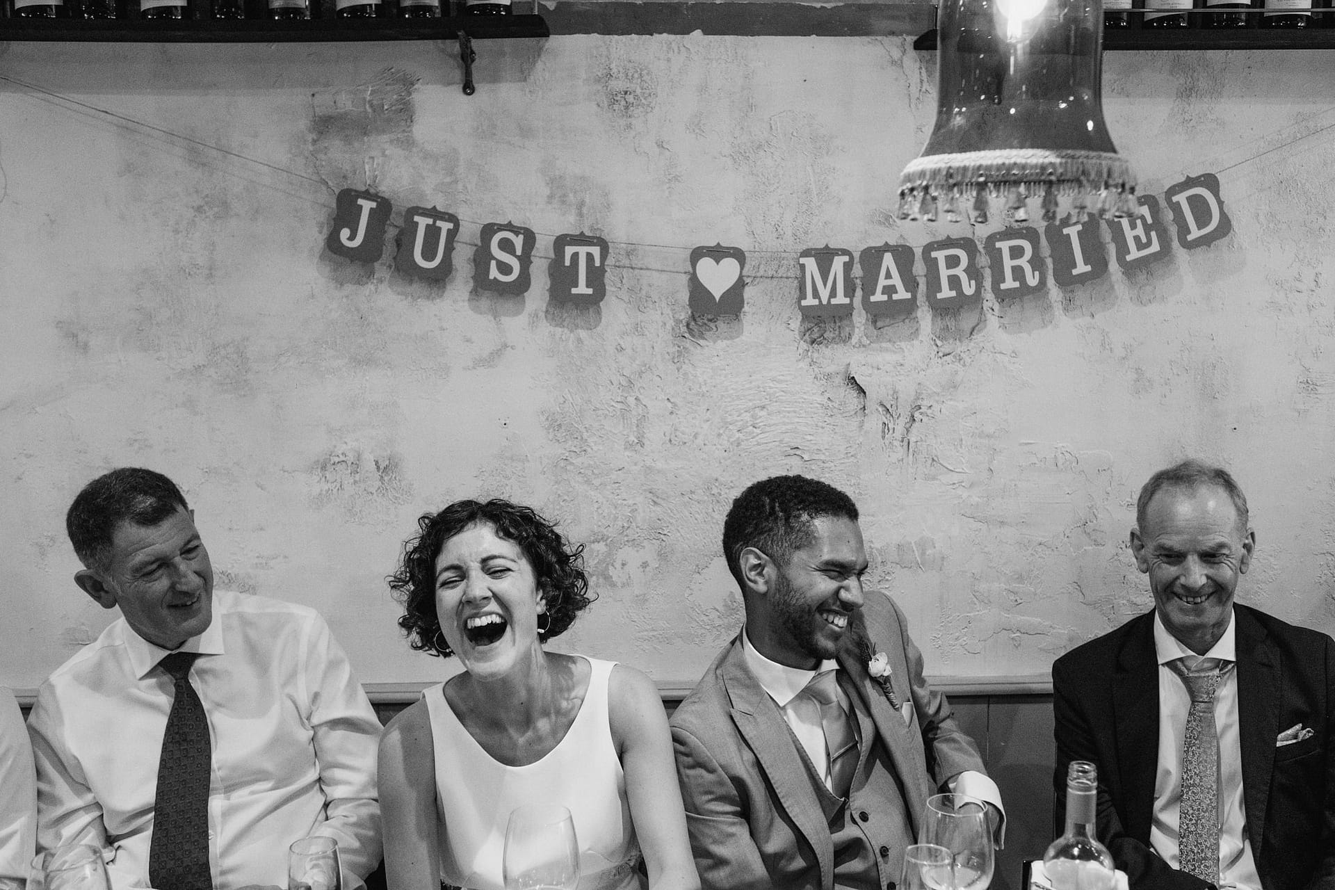 bride and groom laughing with just married sign above their head at La Farola restaurant