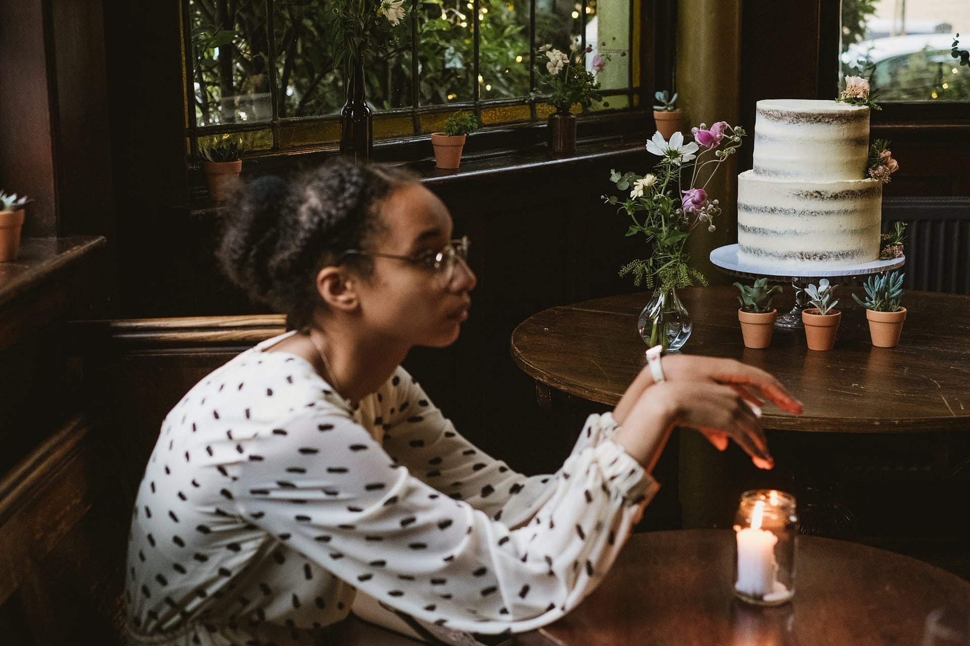 flower girl warming hands on candle at Prince Albert pub in Camden