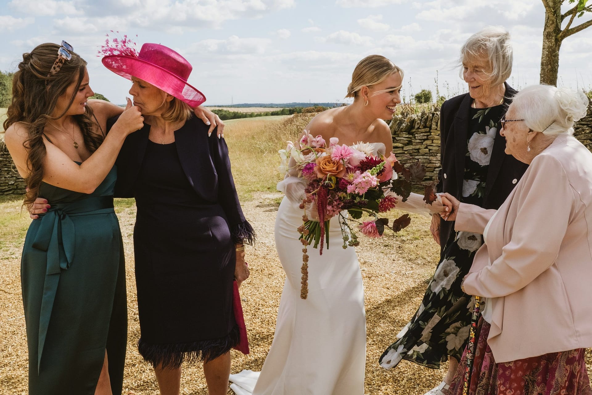stone barn wedding photography. bride shaking hand with relatives and mother of the bride sharing a moment with her other daughter.