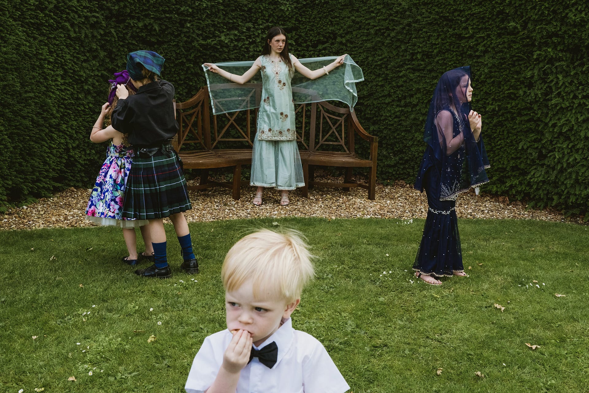 Group in garden wearing cultural and formal attire.