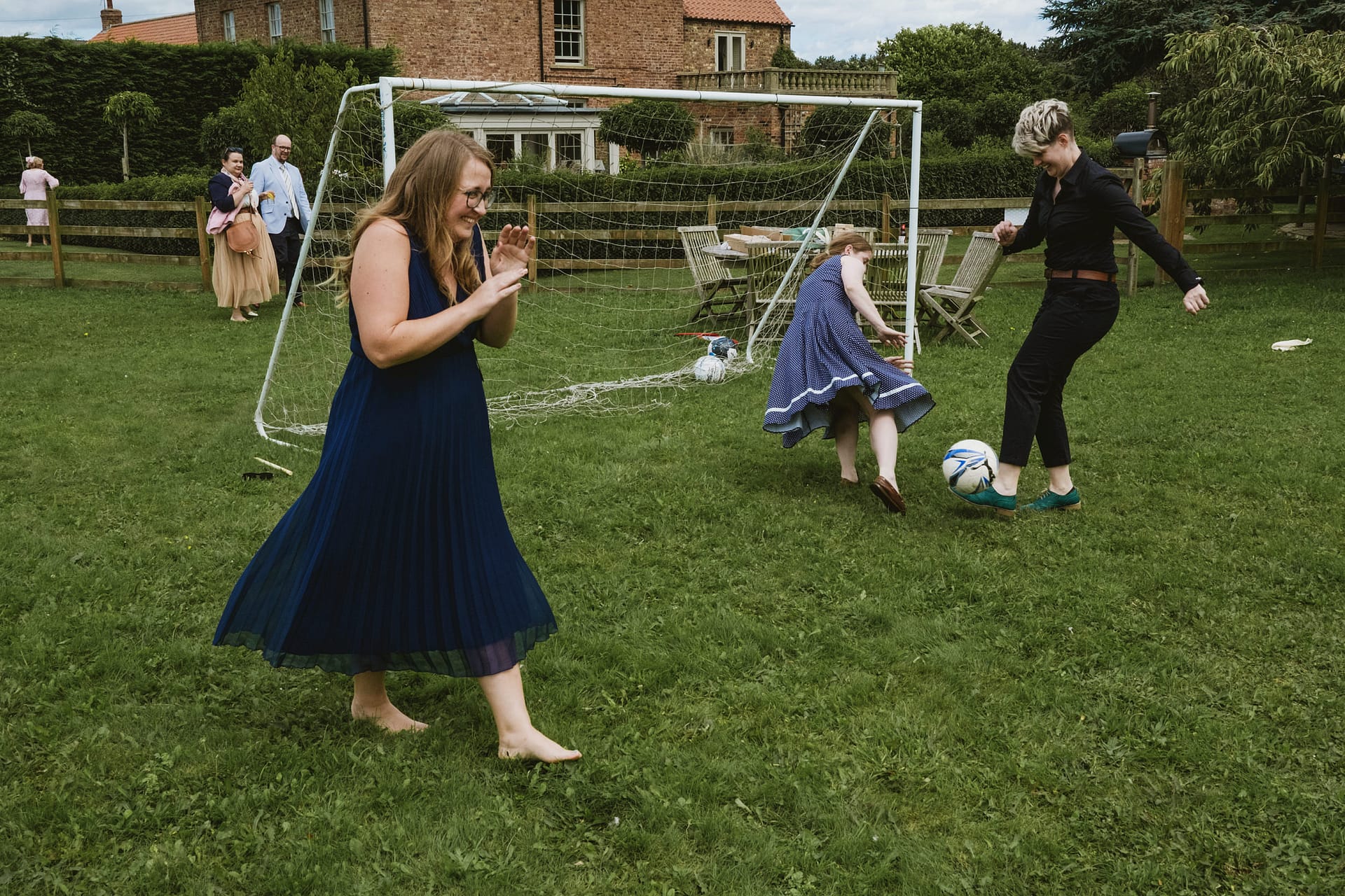 People playing football in garden, enjoying sunny day