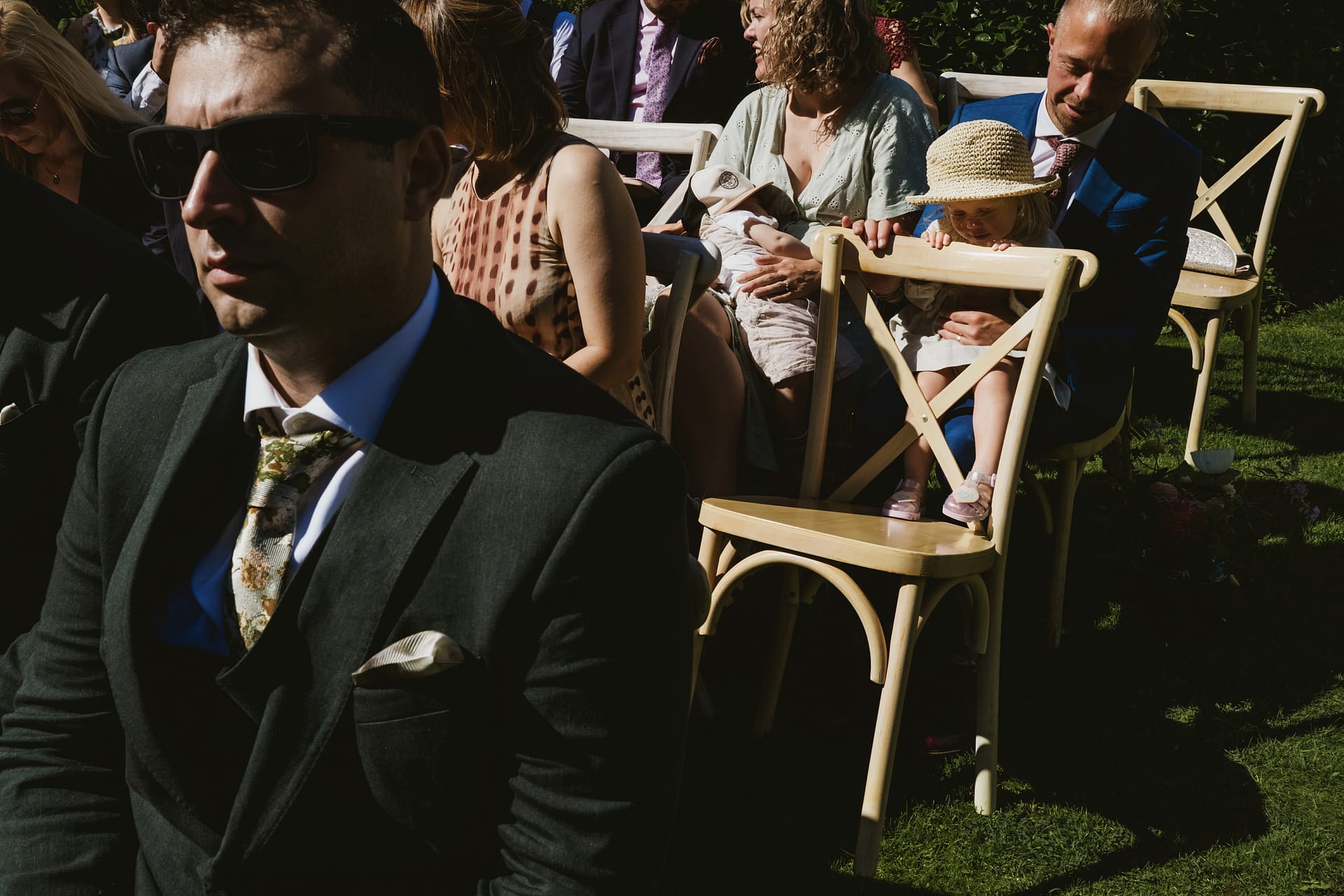 Guests seated outdoors at a wedding ceremony.