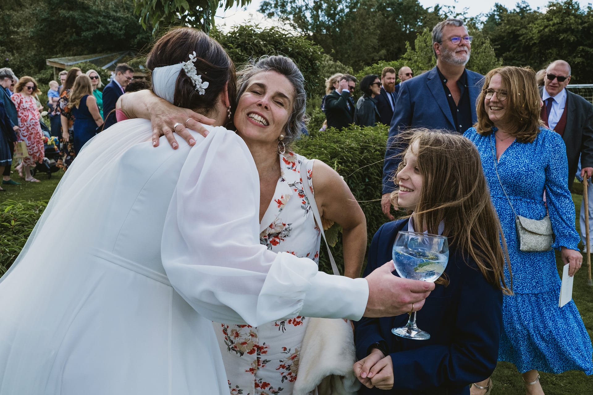 Guests celebrating at outdoor wedding gathering.
