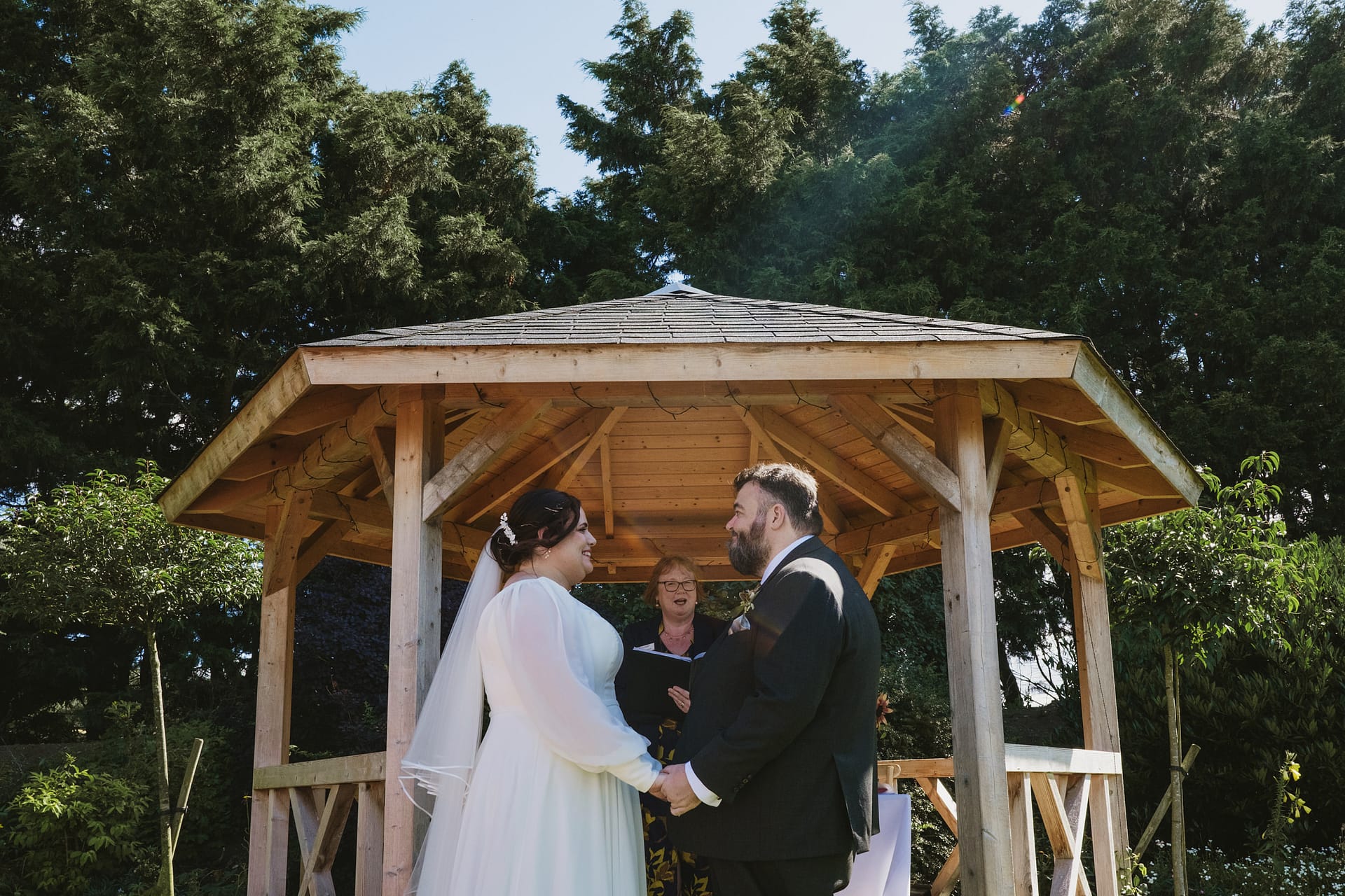 Couple exchanging vows at outdoor wedding ceremony.