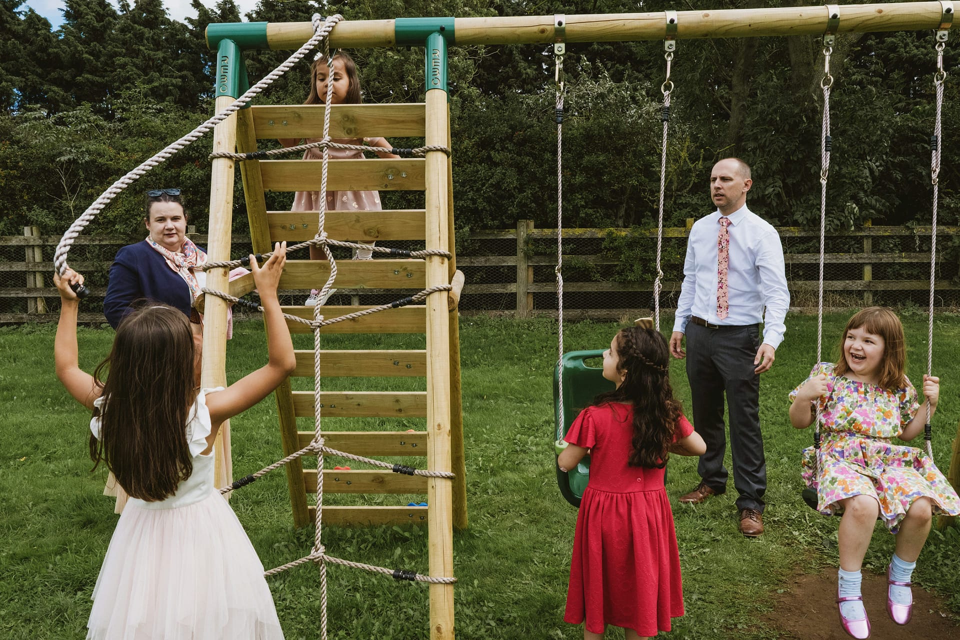 Children playing on playground with supervising adults.