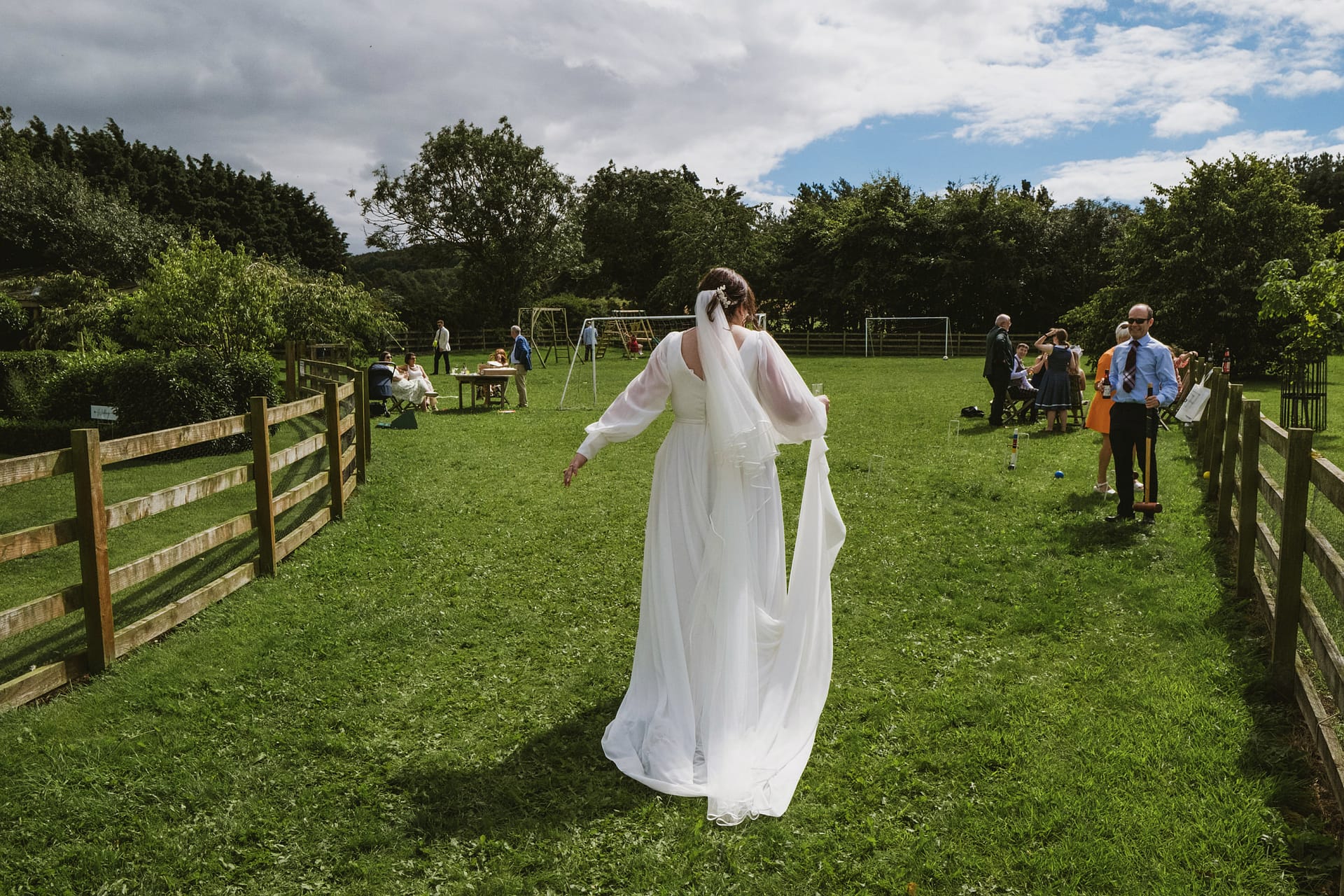 Bride walking in outdoor wedding celebration.