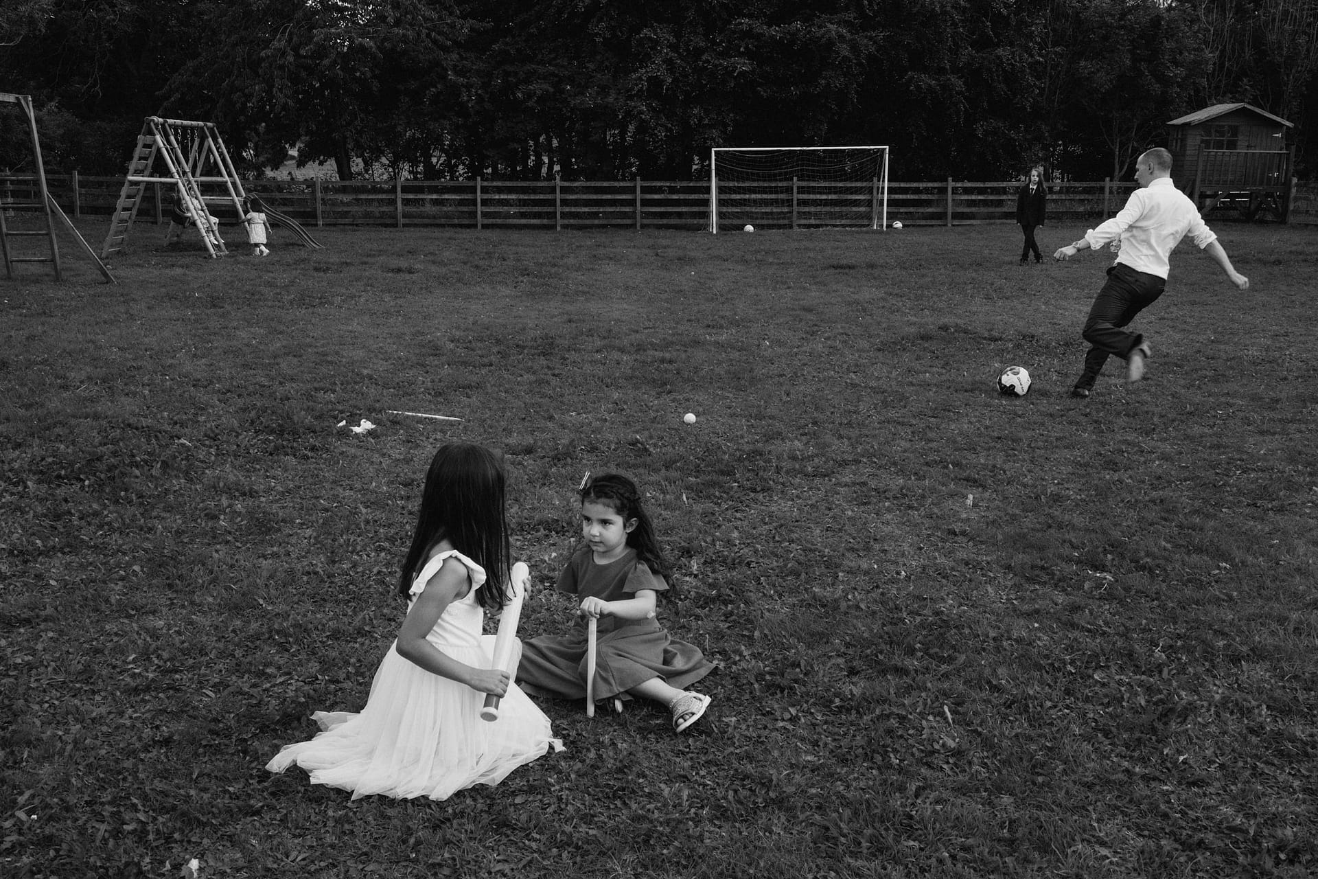 Children playing in a park with swings and football.