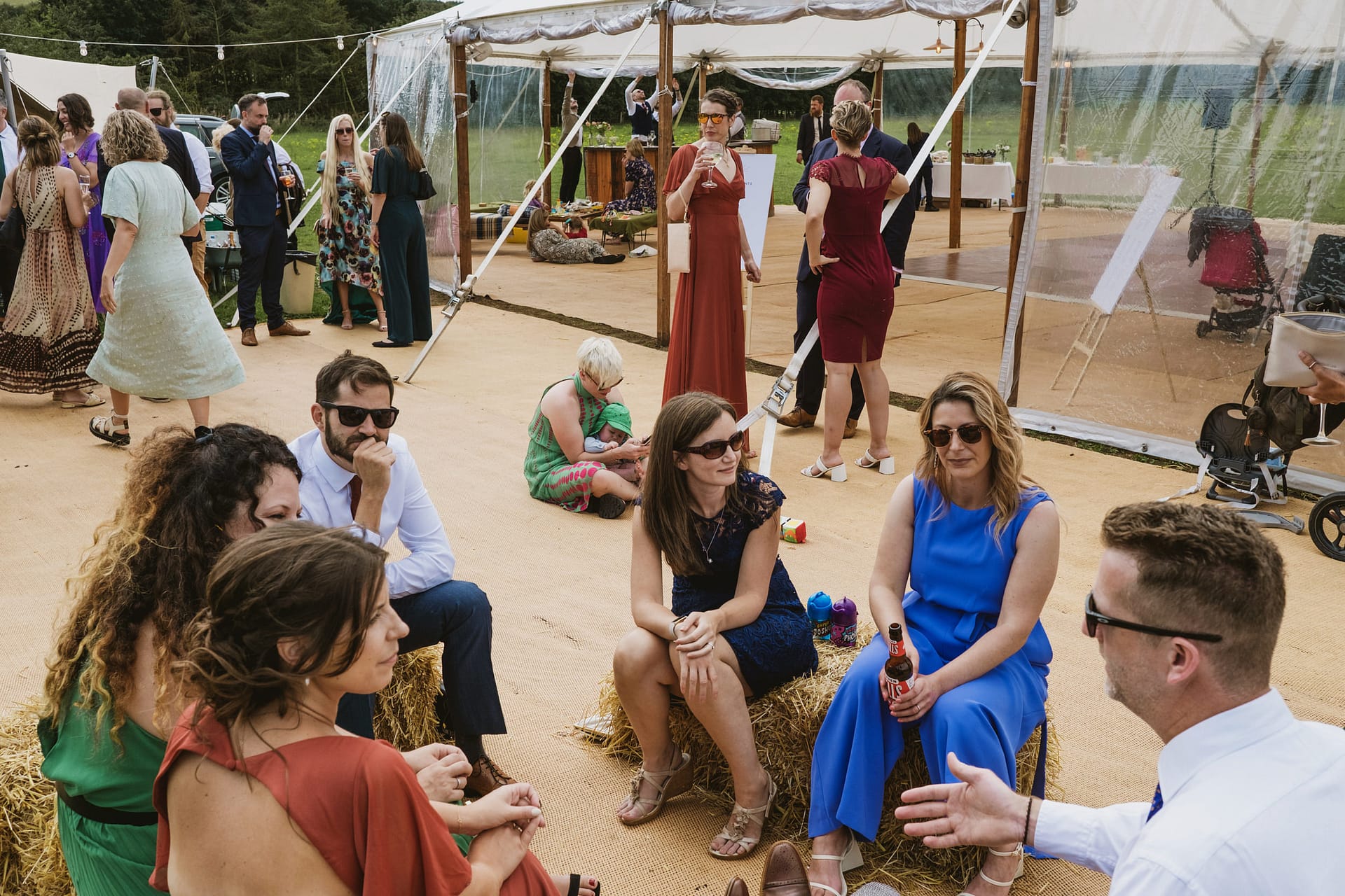Outdoor gathering with people socialising under a marquee.