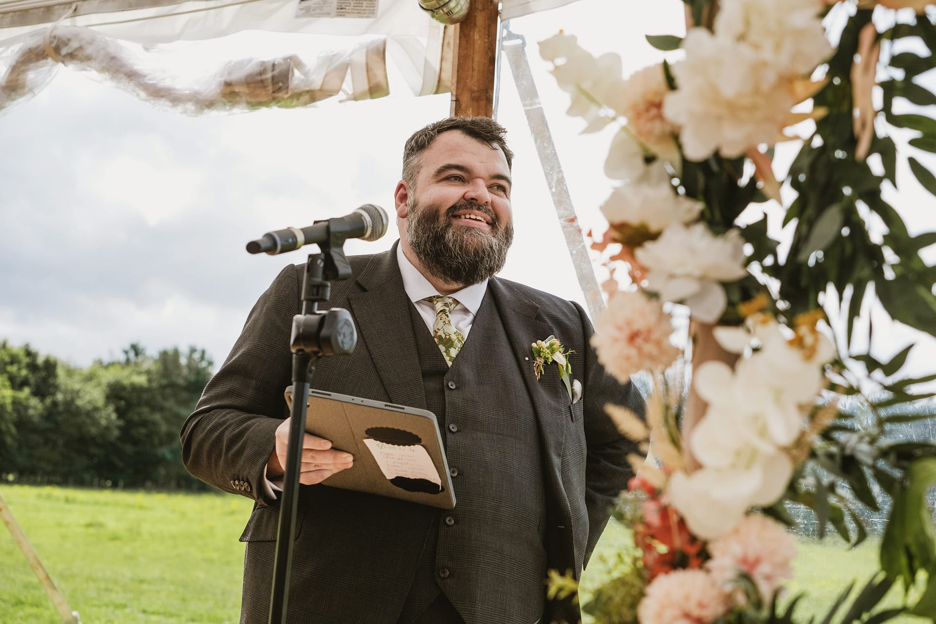 Smiling man giving outdoor speech at wedding