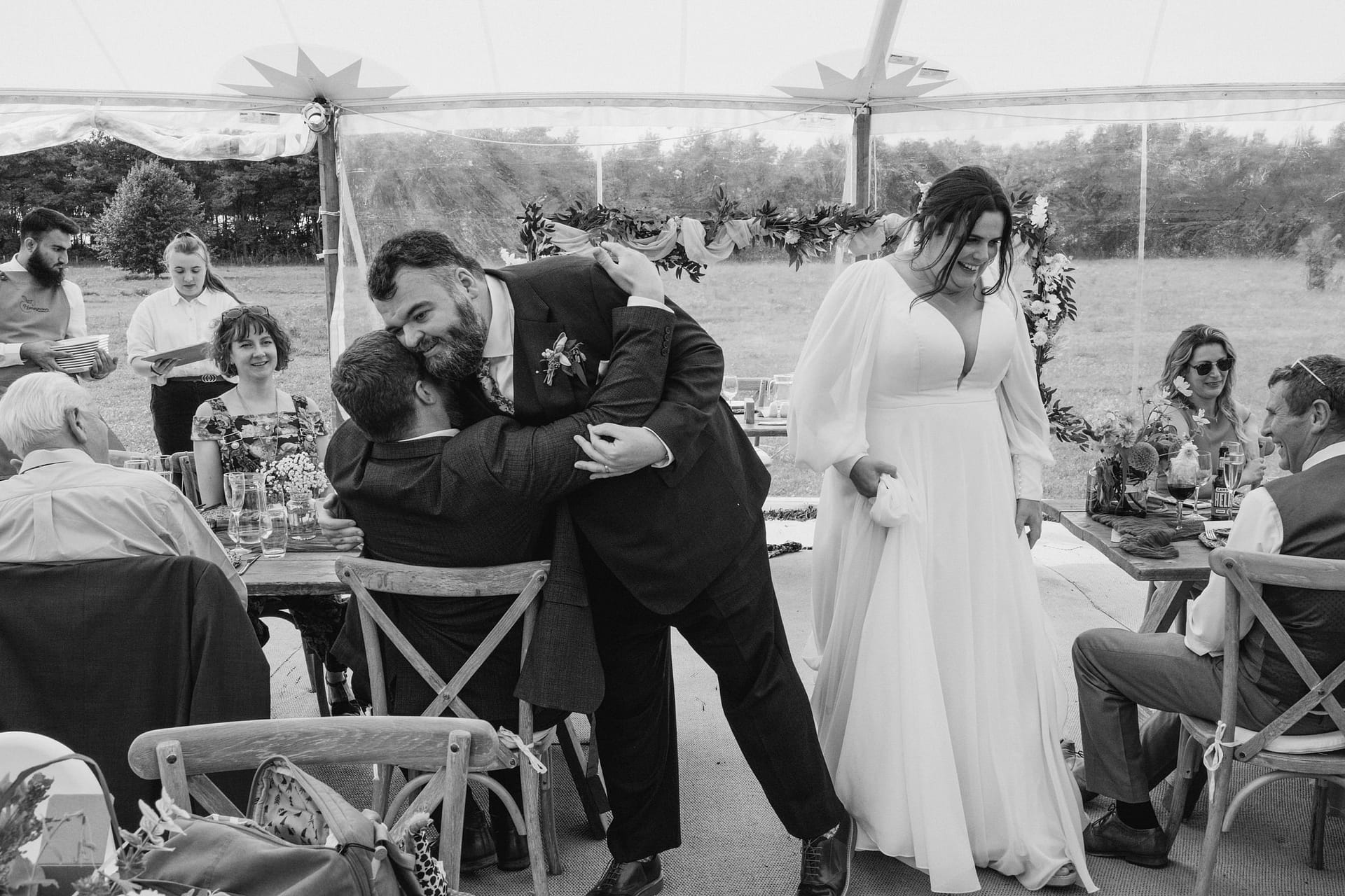 Wedding celebration under a tent with guests.