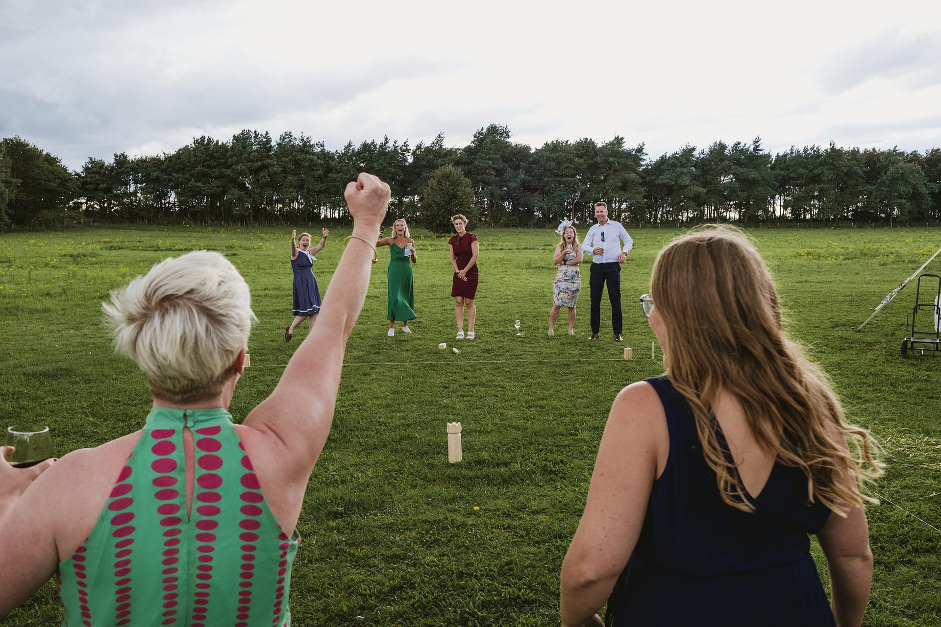 People playing outdoor lawn game in field.