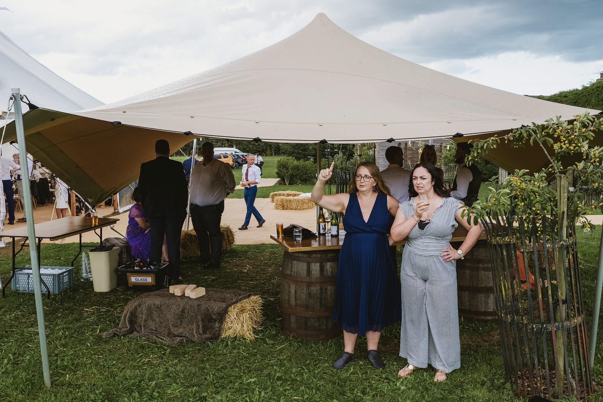 People socialising under a marquee at outdoor event.