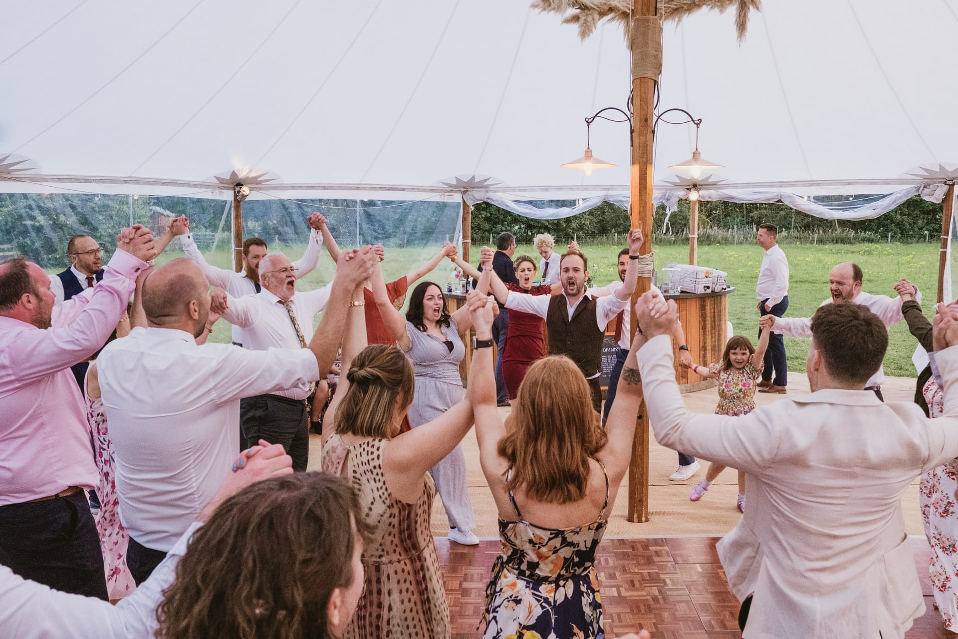 Group celebrating at outdoor event in marquee.