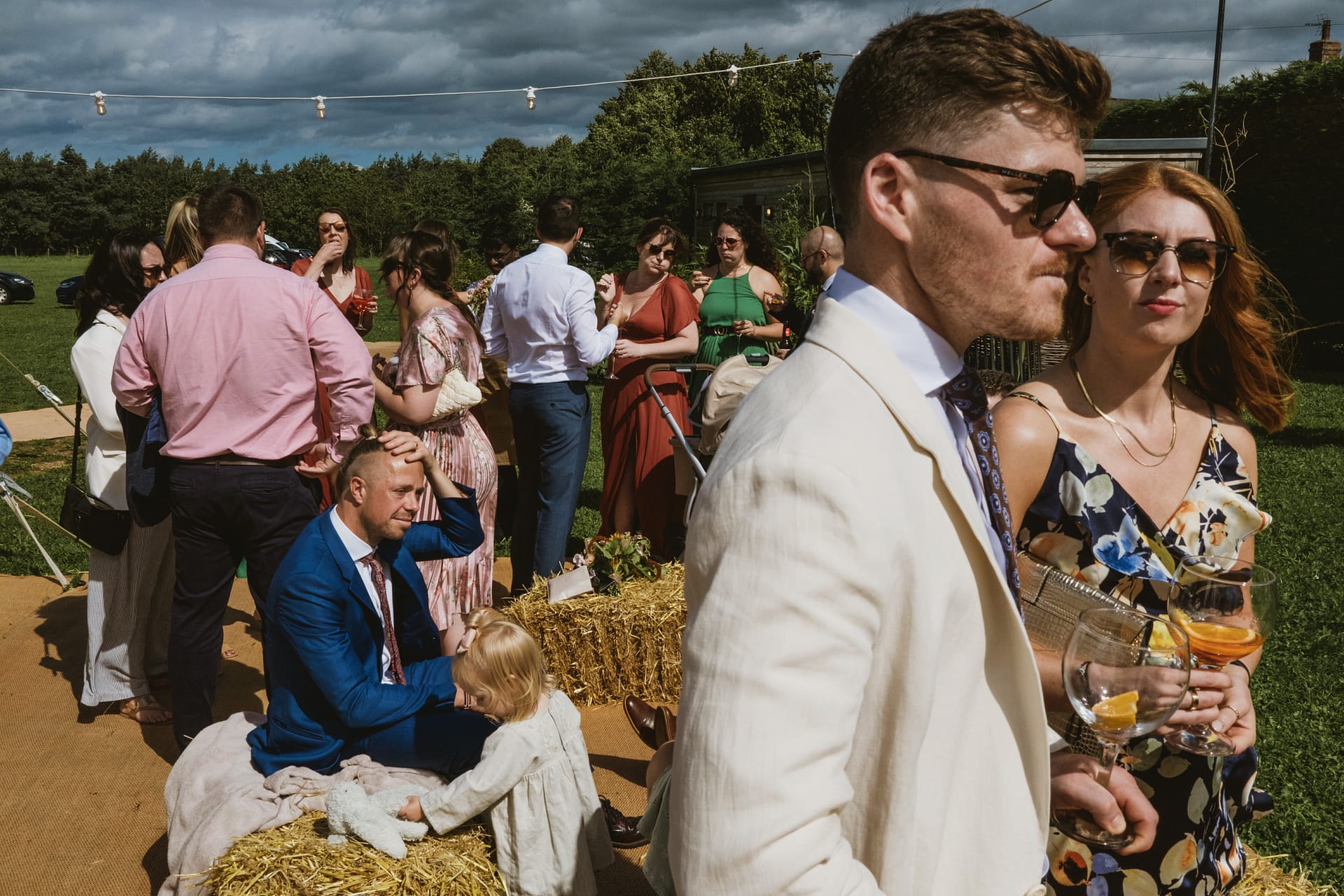 Outdoor gathering with people dressed smartly, lively atmosphere.
