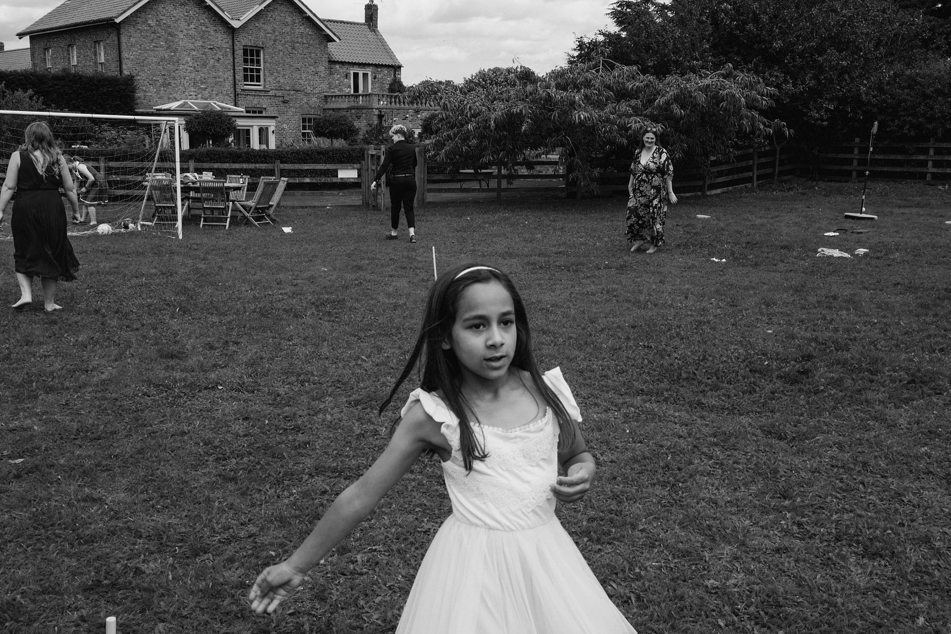 Young girl in dress playing outside in garden.