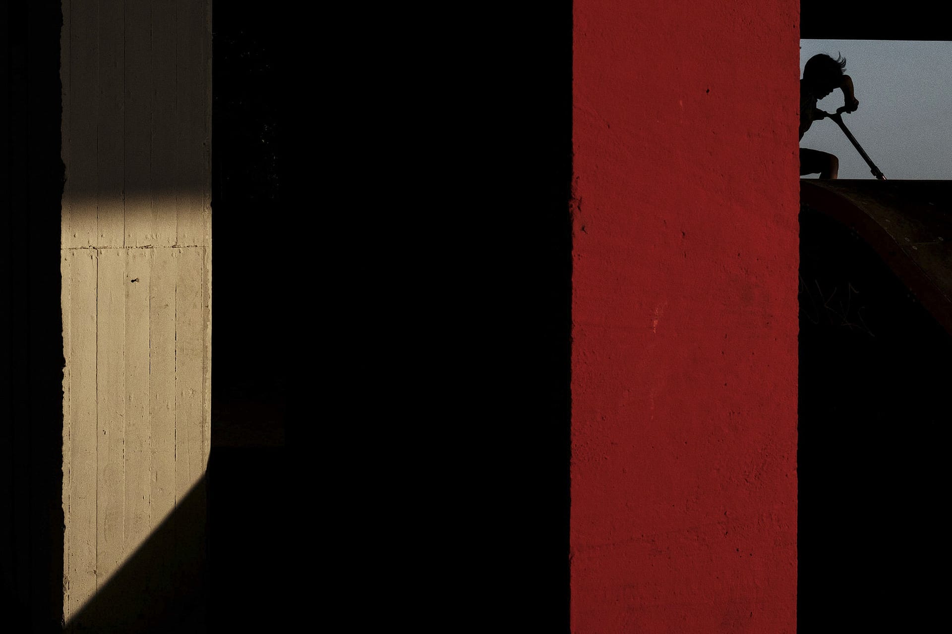 Street photograph captured in Budapest, Hungary. Figure is silhouetted in the top right corener, amongst multiple stripes of light and colour.