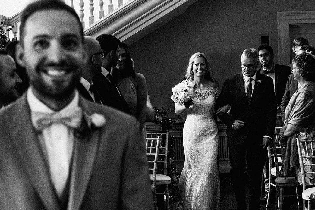 groom waiting in anticipation for bride at Morden Hall in black and white
