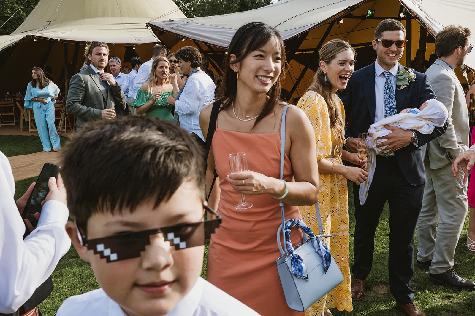 Wedding guests conversing in front of a Tipi at Battersea Park, London