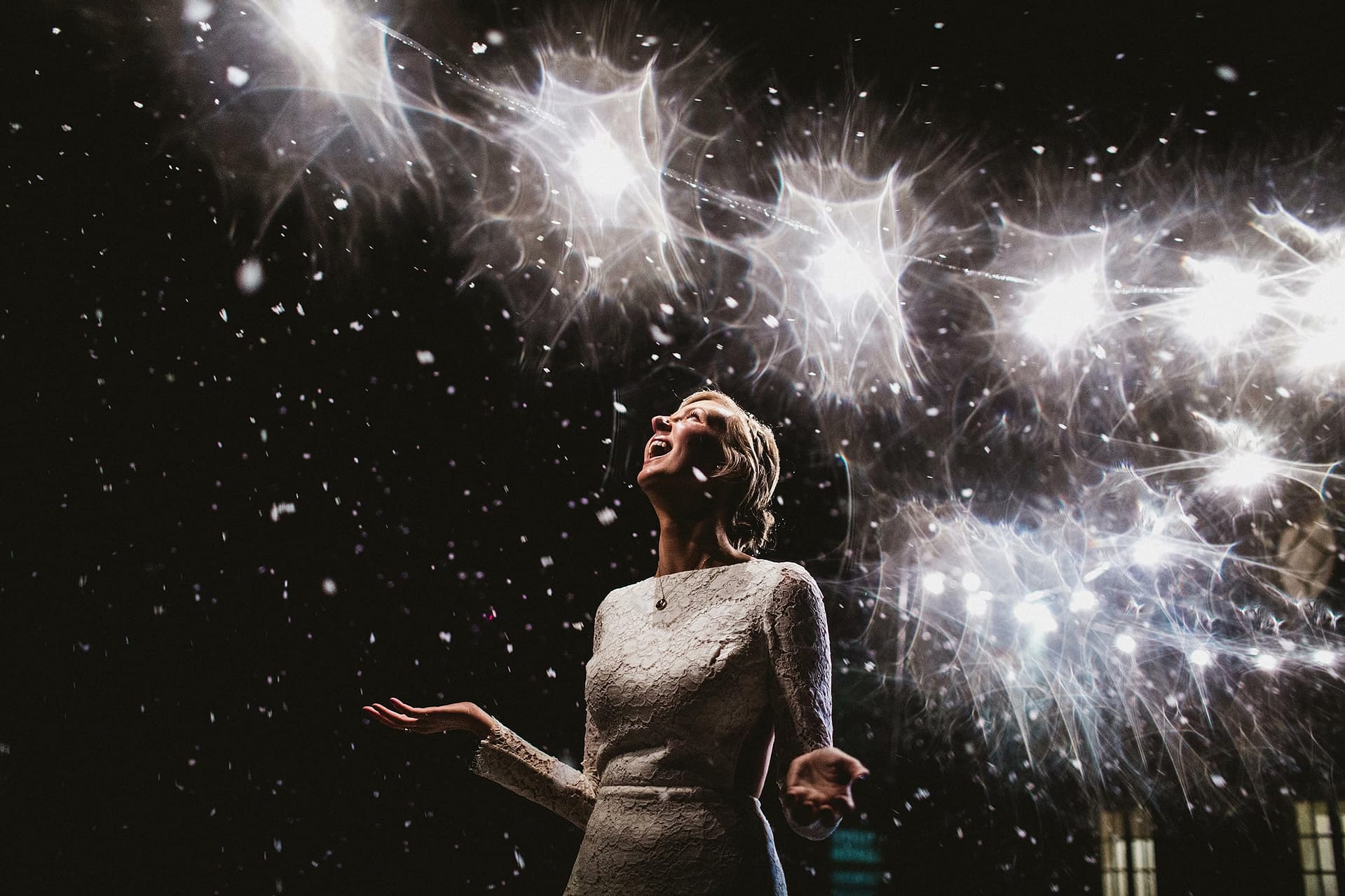 Broughton Hall Wedding Photography Skipton. Bride looking up snow falling down around her