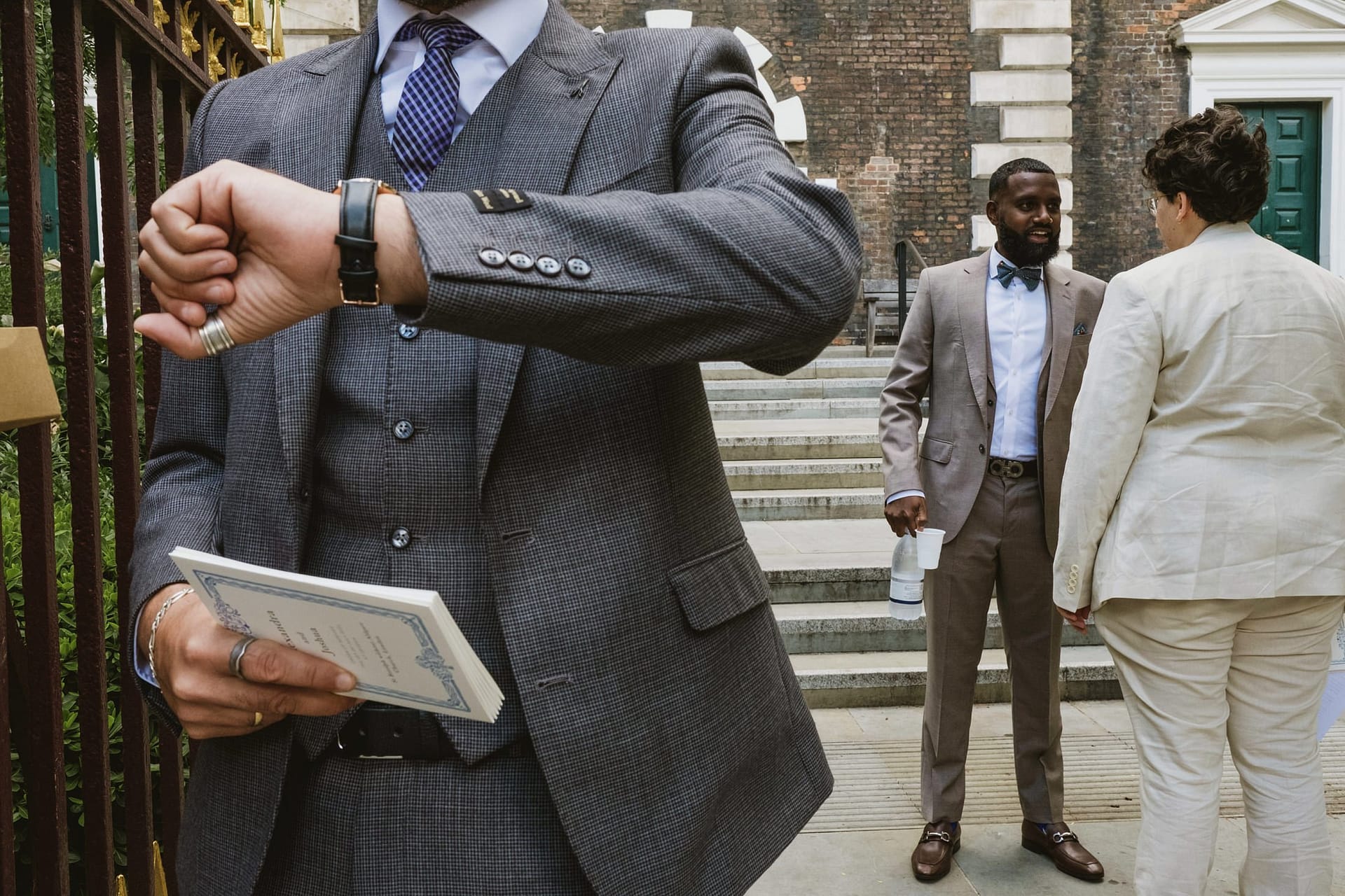 A man in a suit holding a book next to another man in a suit at St Botolph without Aldgate.