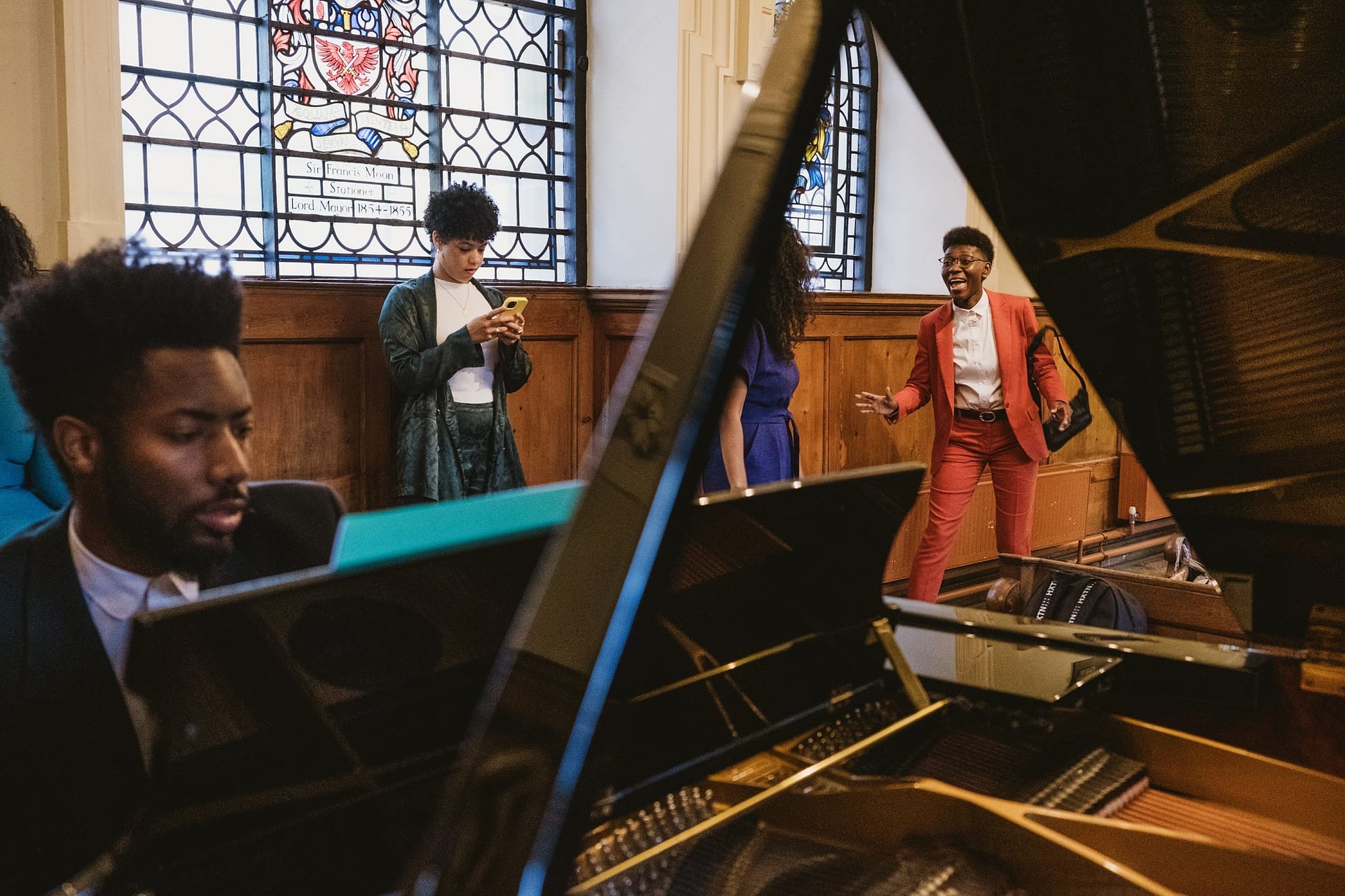 A group of people playing a piano in St Botolph without Aldgate church.