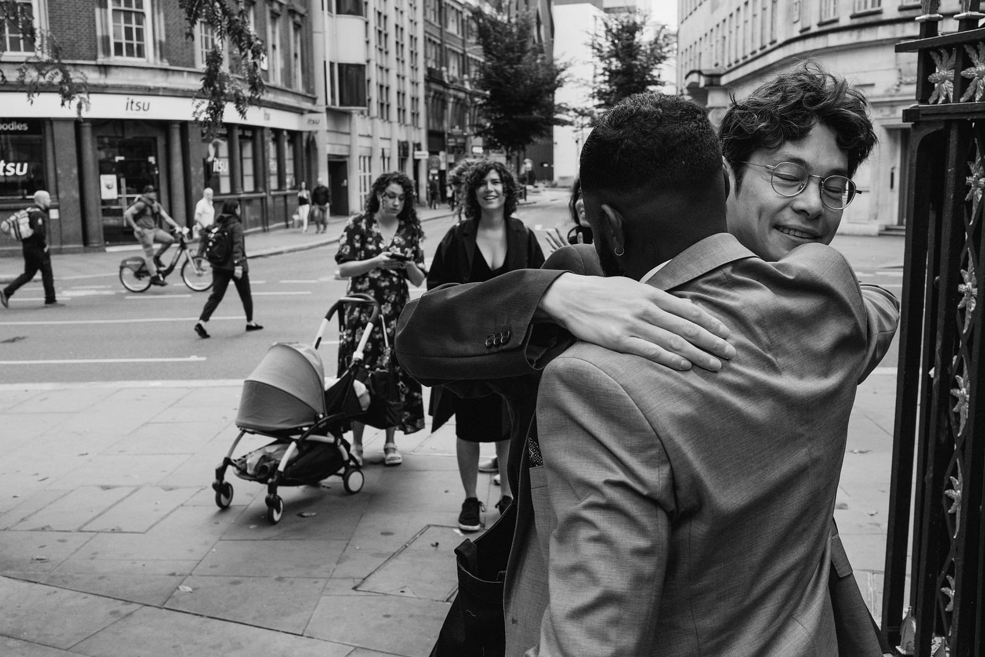 A black and white photo of two men embracing in the historic neighborhood of St Botolph without Aldgate.