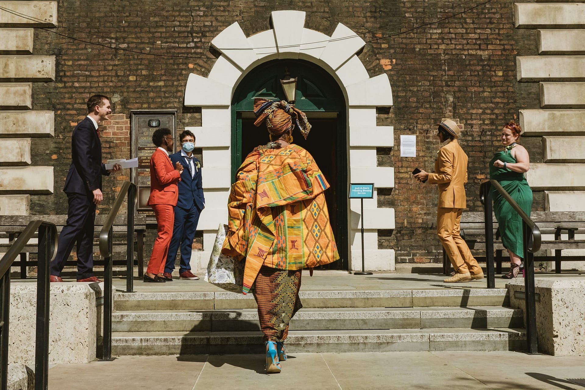 A group of people walking down the steps of St Botolph without Aldgate building.