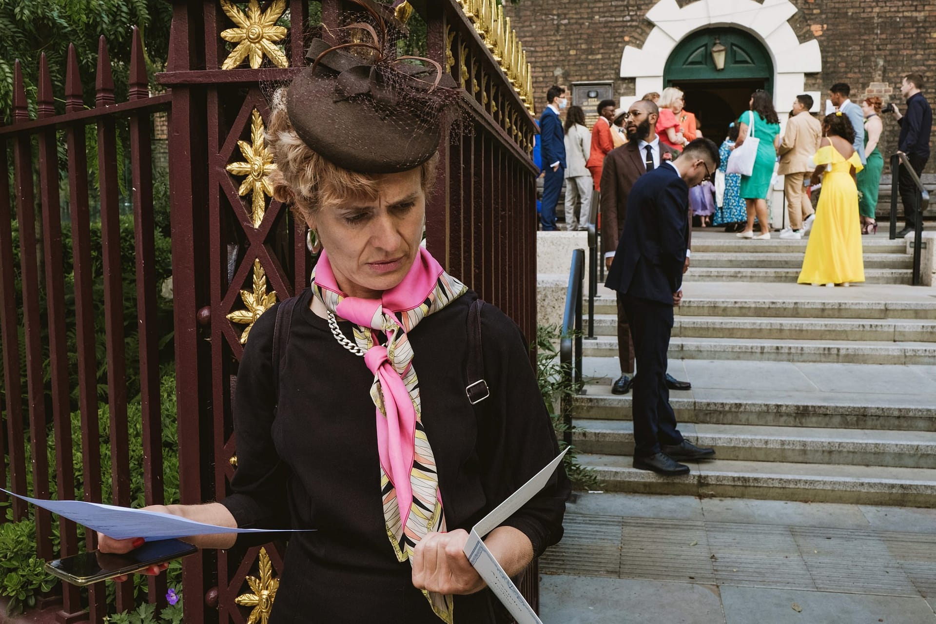 A woman holding a piece of paper in front of a group of people during an event at St Botolph without Aldgate.