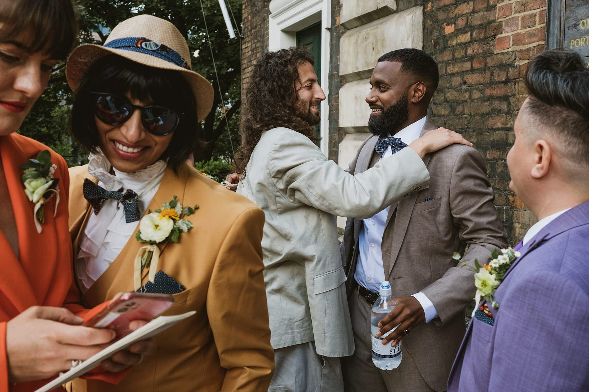 A group of people in suits and hats talking to each other at St Botolph without Aldgate.