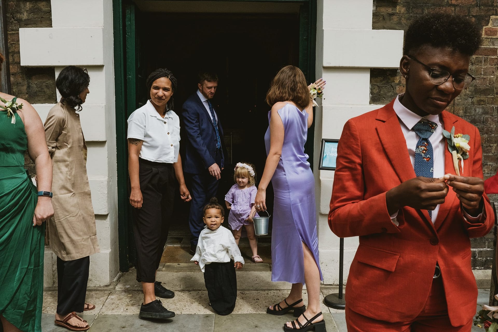 Greenwich Yacht Club Wedding Photography captures a group of people standing in front of a door, immortalizing the special moment with stunning imagery.