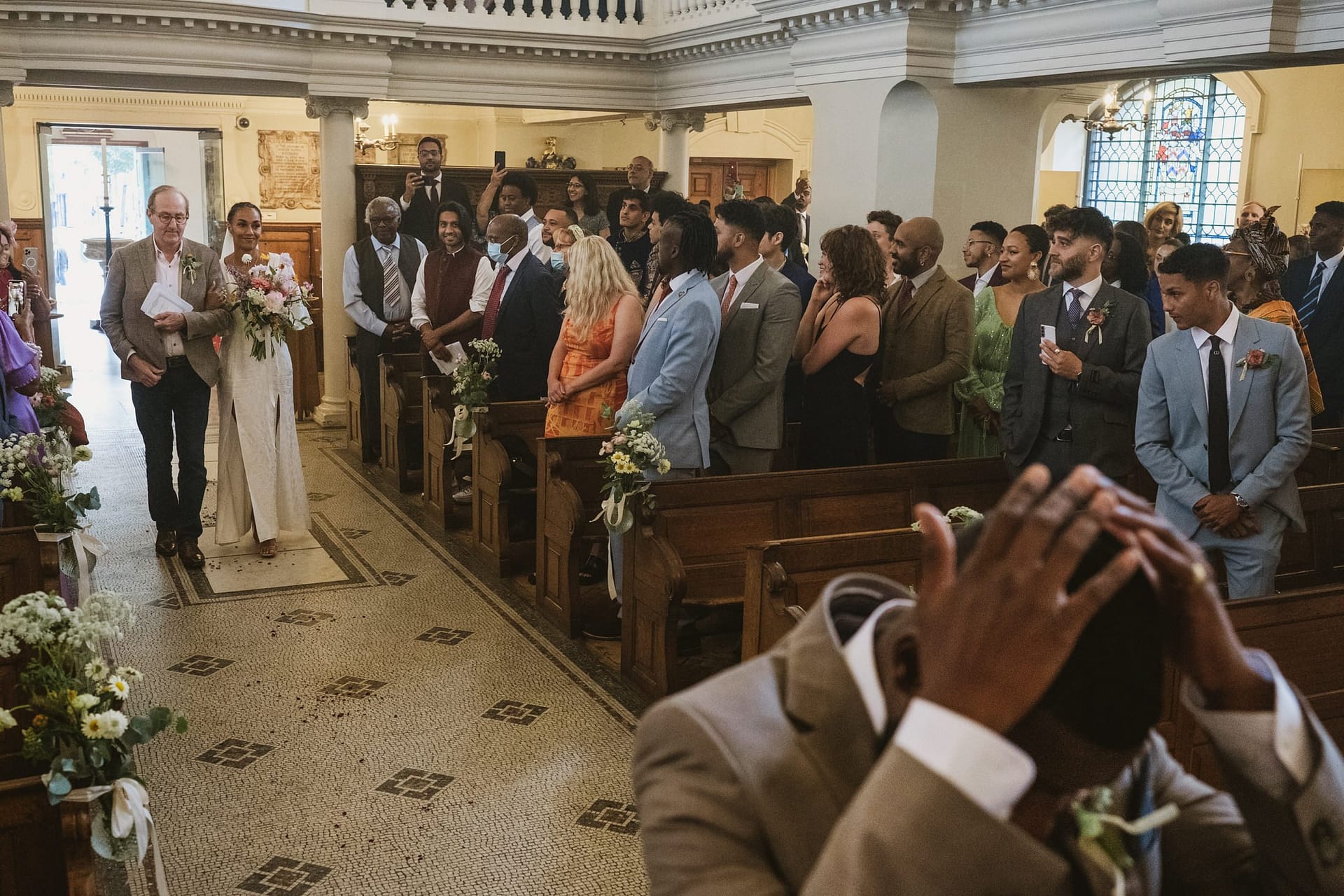 A bride walking down the aisle in a church during the St Botolph wedding ceremony.
