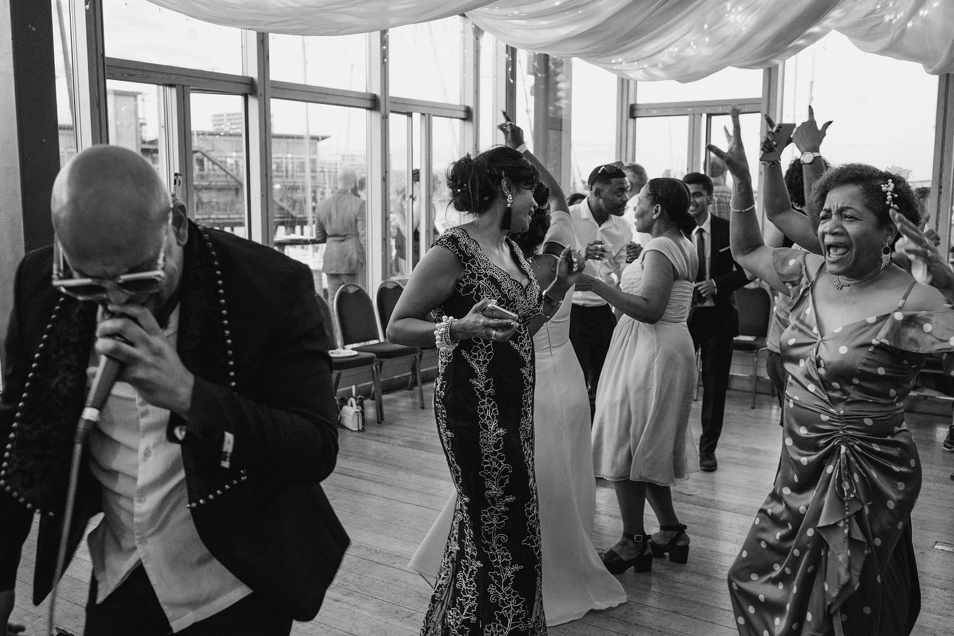 Greenwich Yacht Club wedding photography captures a timeless and elegant black and white photo of people joyfully dancing.