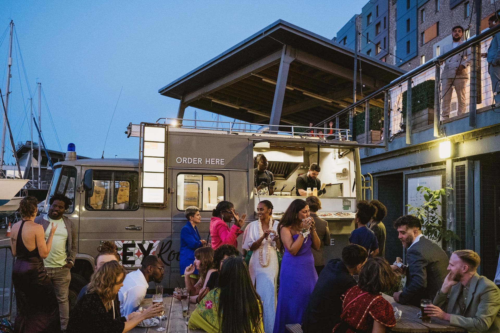 A group of people gathered around a food truck at a Greenwich Yacht Club Wedding.