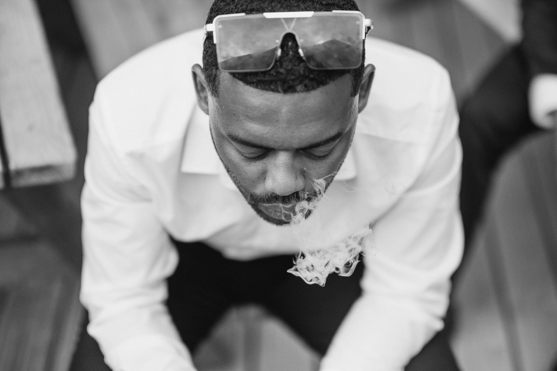 A man is enjoying a cigarette on a deck at the Greenwich Yacht Club.