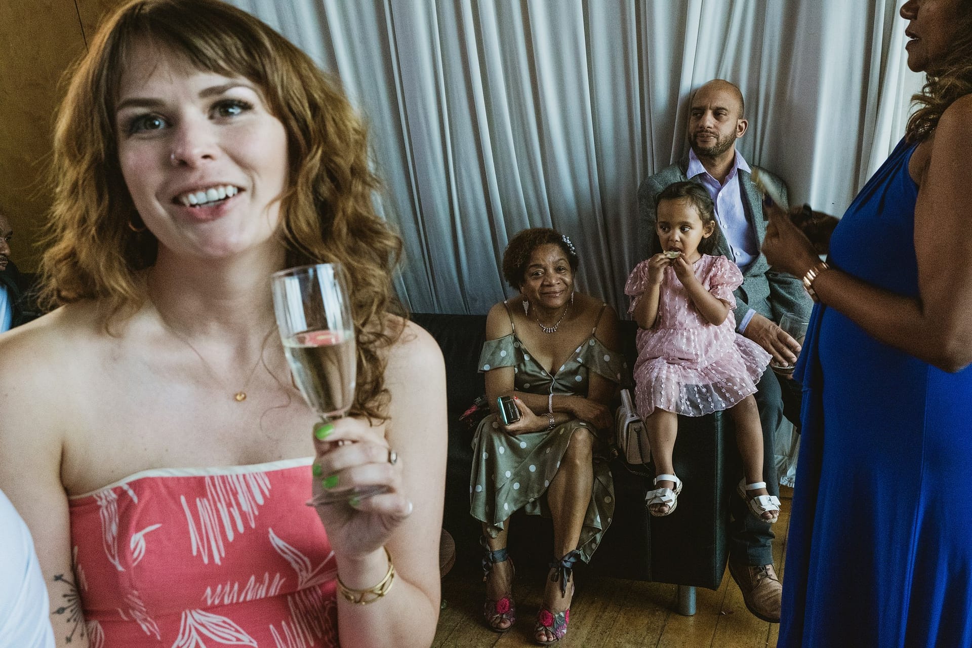 A woman is elegantly holding a glass of champagne during a Greenwich Yacht Club wedding celebration.