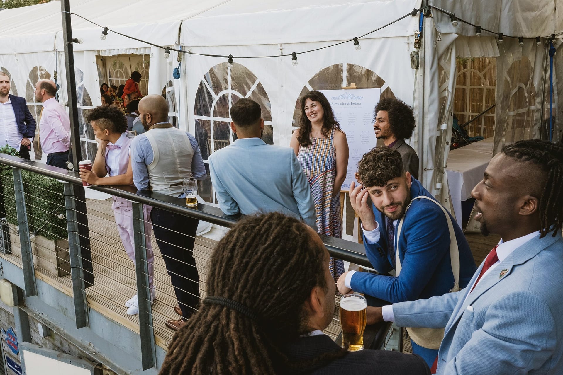 A group of people standing around a white tent at a Greenwich Yacht Club wedding.