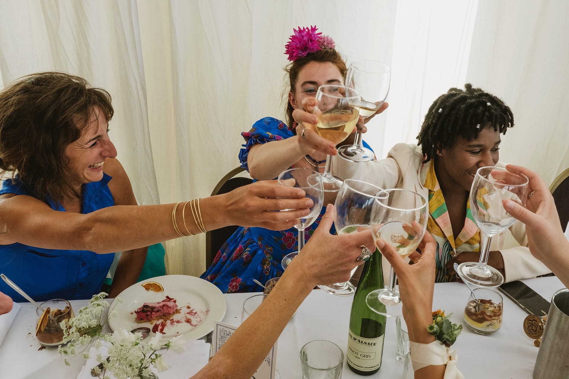 A group of women, elegantly dressed, holding wine glasses at a glamorous Greenwich Yacht Club wedding, captured beautifully through expert photography.