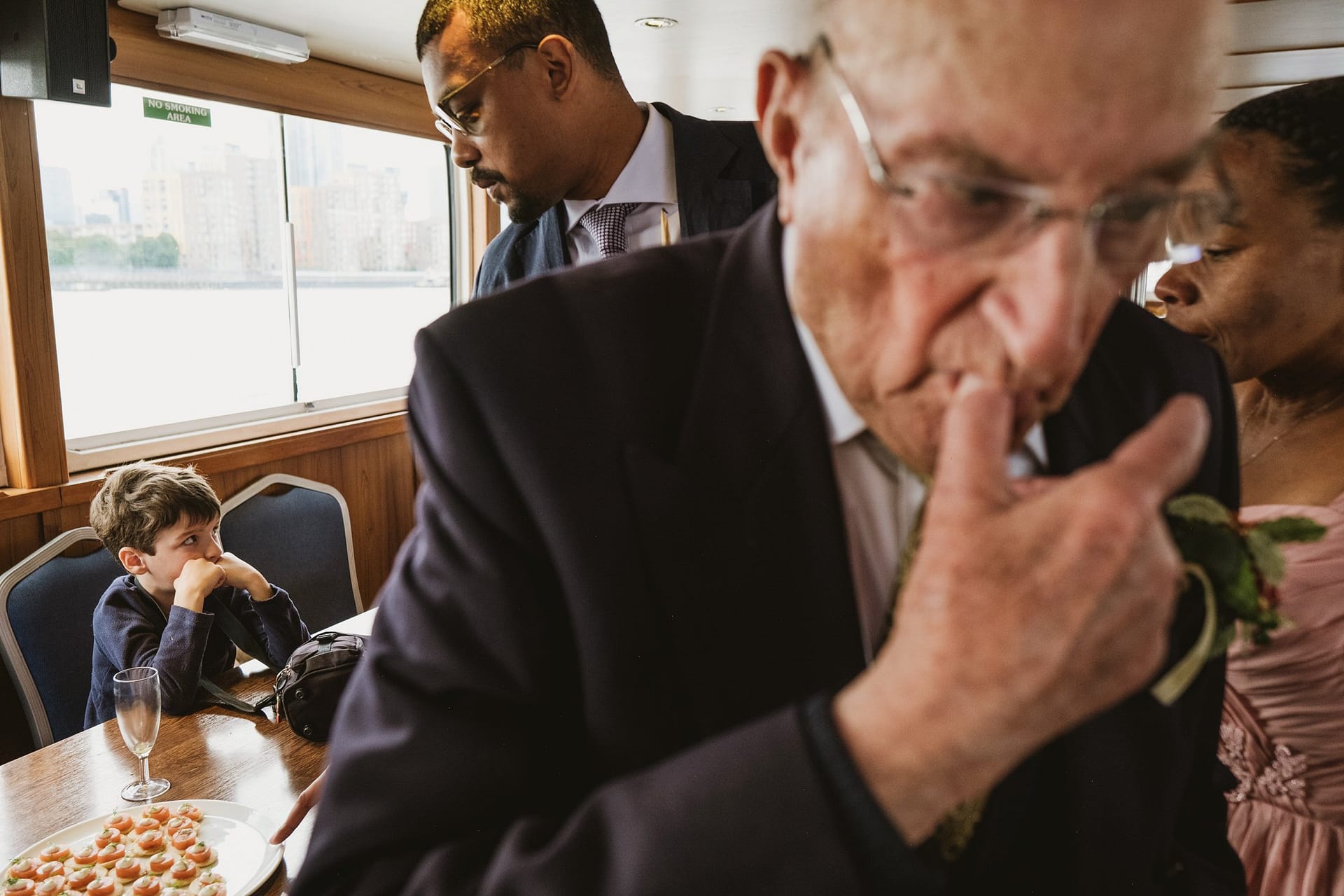 A man in a suit is enjoying a delicious cake on a luxurious boat at Greenwich Yacht Club.